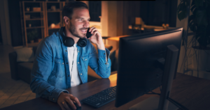 a man sitting at a desk talking on the phone